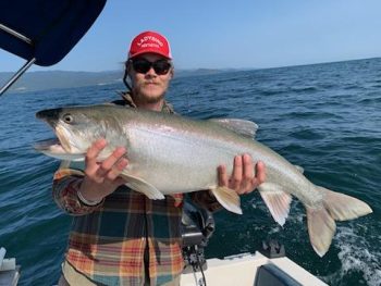 man on boat holding caught fish