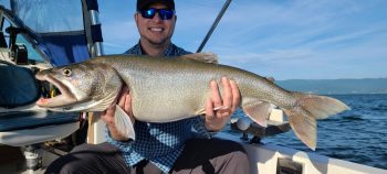 man on boat holding caught fish