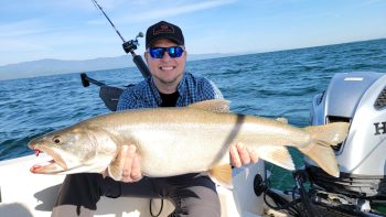 man on boat holding caught fish