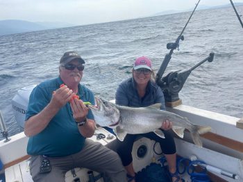 man on boat holding caught fish