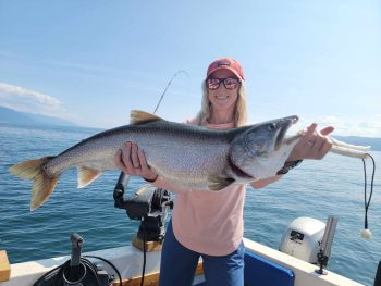 woman in boat holding caught fish
